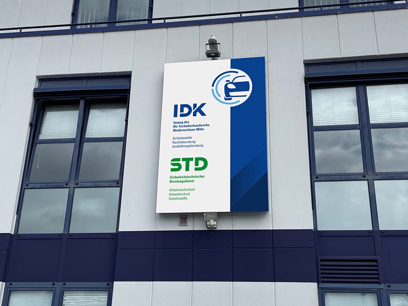 Fassadenschild mit individueller Werbetechnik und Firmenlogo am Gebäude.