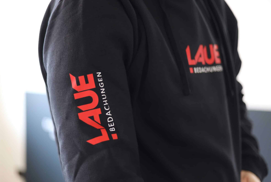 Schwarzer Pullover mit Logo-Veredelung auf Brust und Ärmel.