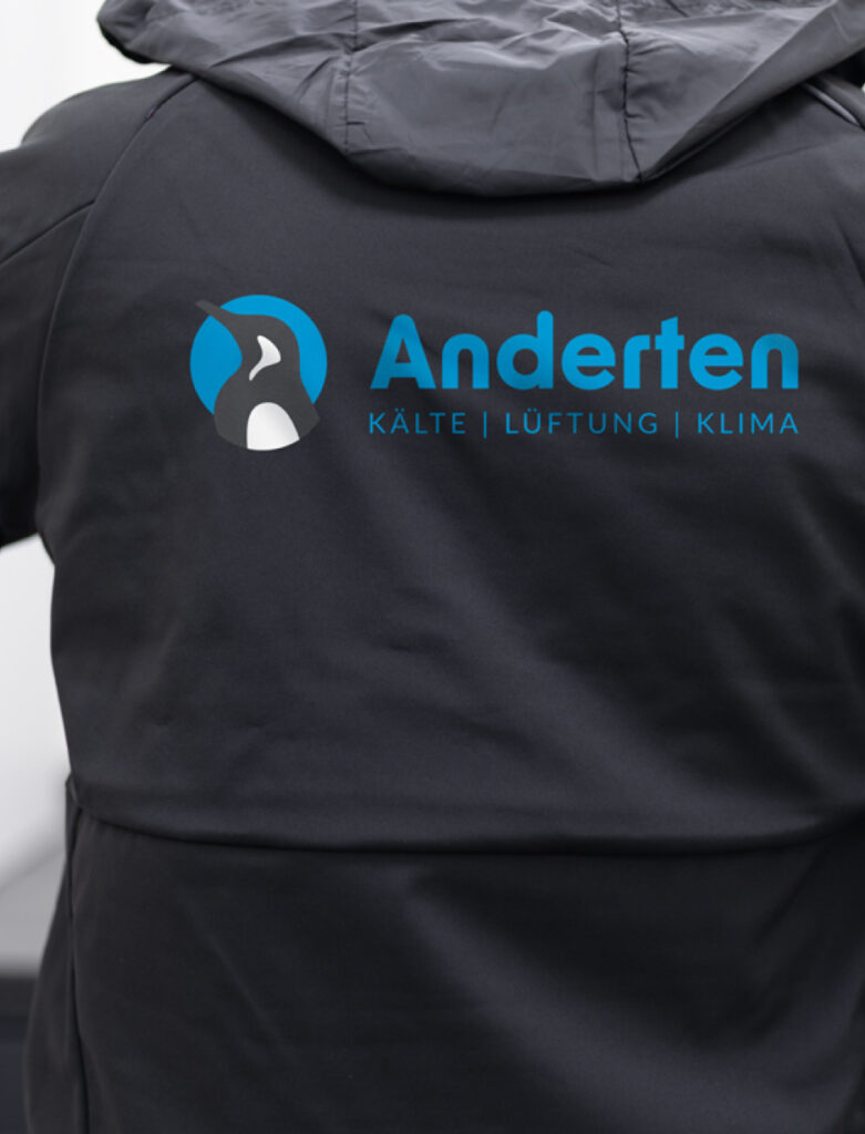 rbeitskleidung mit Firmenlogo für Anderten Kälte + Klima – bedruckte Regenjacke als Referenzprojekt.