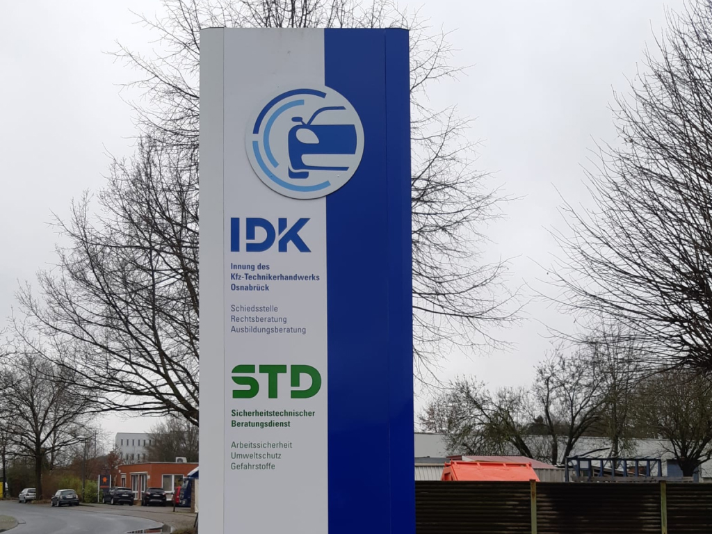 Kombinierte Stele mit IDK und STD Logos als professionelle Außenbeschilderung.